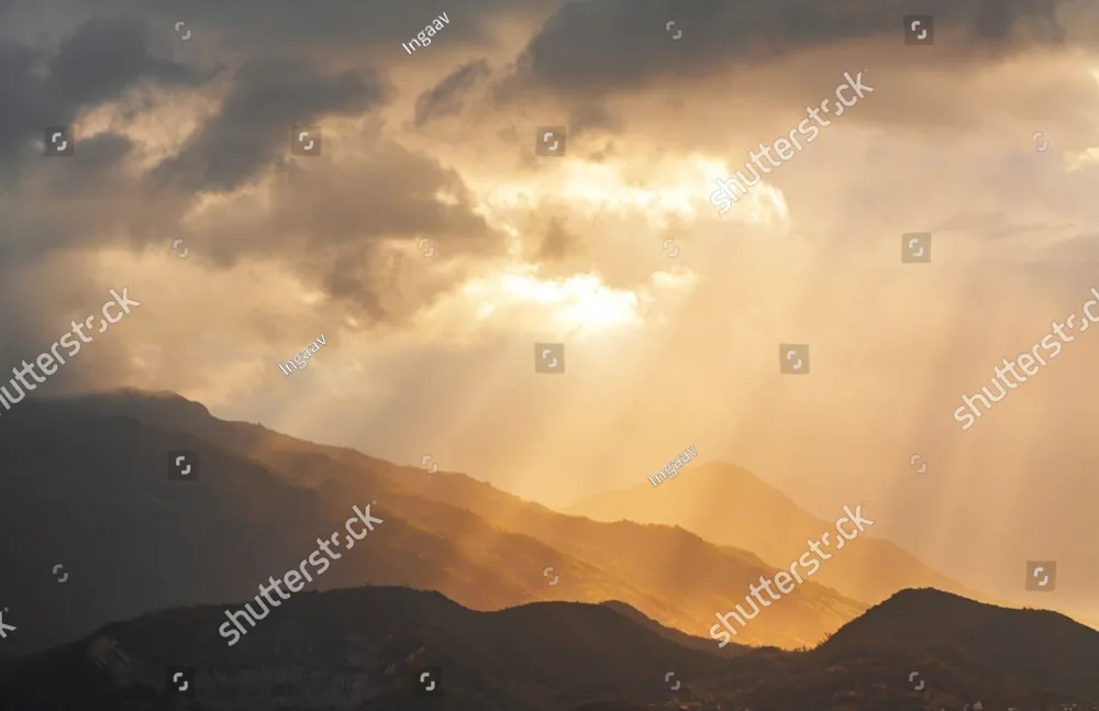 Sunbeams breaking through clouds over the hills