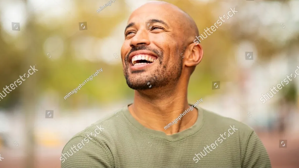 A smiling man outdoors in warm light
